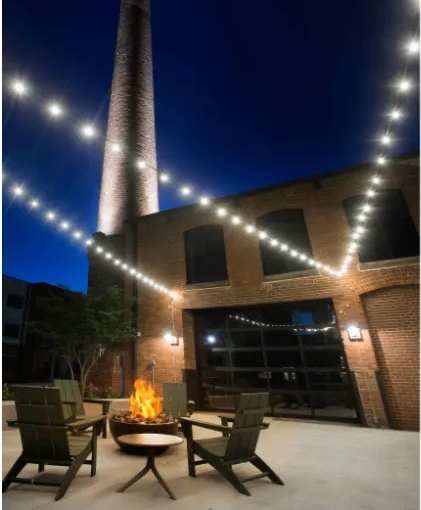 A tall brick chimney is lit up at night.