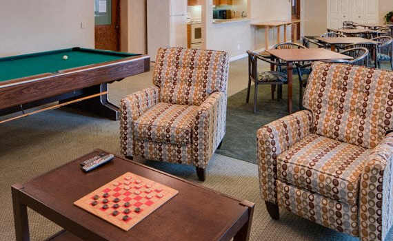a game room with a pool table and chairs