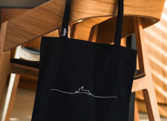 Black bag hanging off wooden chair