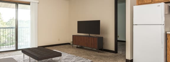 a living room with a couch and a coffee table and a kitchen