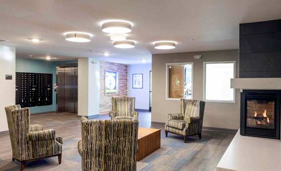 a large lobby with chairs and a fireplace