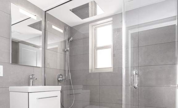 Renovated bathroom with chrome fixtures and spa inspired rain shower