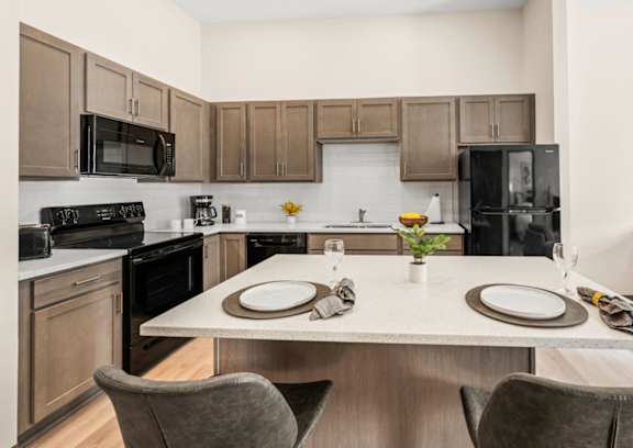 A modern kitchen with a dining table set for two.
