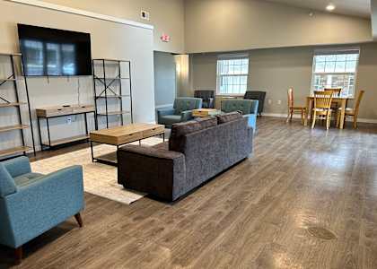 a living room with couches and chairs and a tv