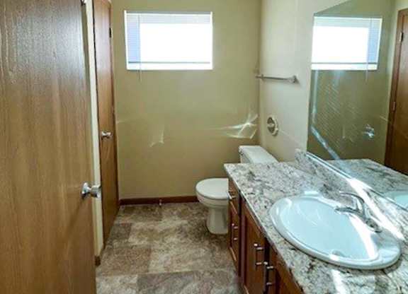 a bathroom with a vanity sink, a mirror, a linen closet, and a window