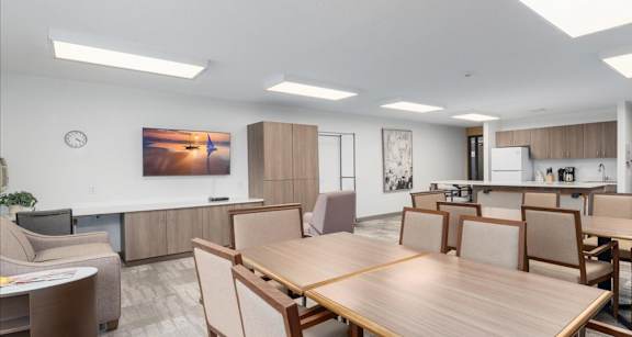 A modern dining room with a large wooden table and chairs.