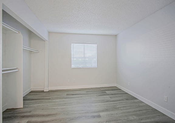A room with a window and wooden flooring.