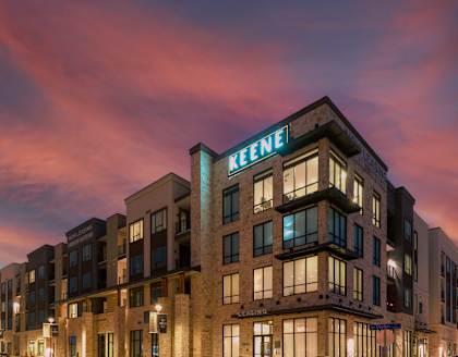 A Keene hotel is shown at dusk with lights on inside.