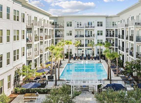 A large white building with a pool in the middle of the courtyard.