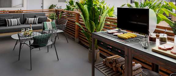 A modern kitchen with a grill and a dining table.