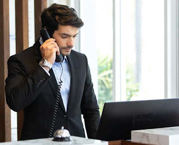 a man talking on the phone at a desk with a laptop at Element, Tampa, 33602