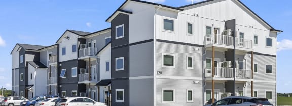 an apartment building with cars parked in front of it