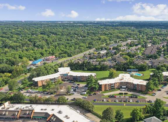 A bird's eye view of a large building complex surrounded by trees.