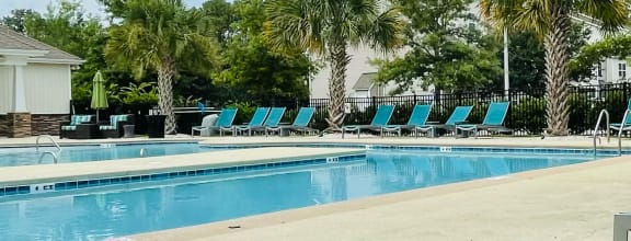 Beautiful pool with loungers at Oasis at Cedar Branch in Wilmington, NC