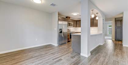 A spacious kitchen with a refrigerator, stove, and oven.