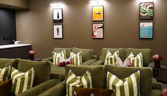 a living room with couches and pictures on the wall
