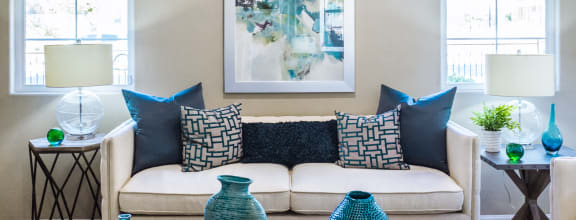 couch with blue pillows and windows