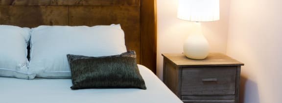 a bedroom with a bed and a nightstand with a lamp