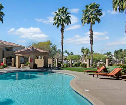 The outdoor pool with pool chairs, tables, and chairs at Dobson Towne Centre. 