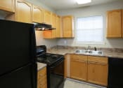 Thumbnail 4 of 29 - a kitchen with black appliances and wooden cabinets