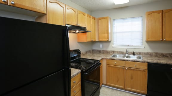 a kitchen with black appliances and wooden cabinets