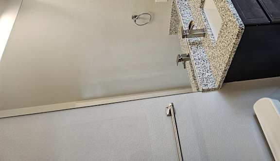 A bathroom with a black cabinet and a white toilet.