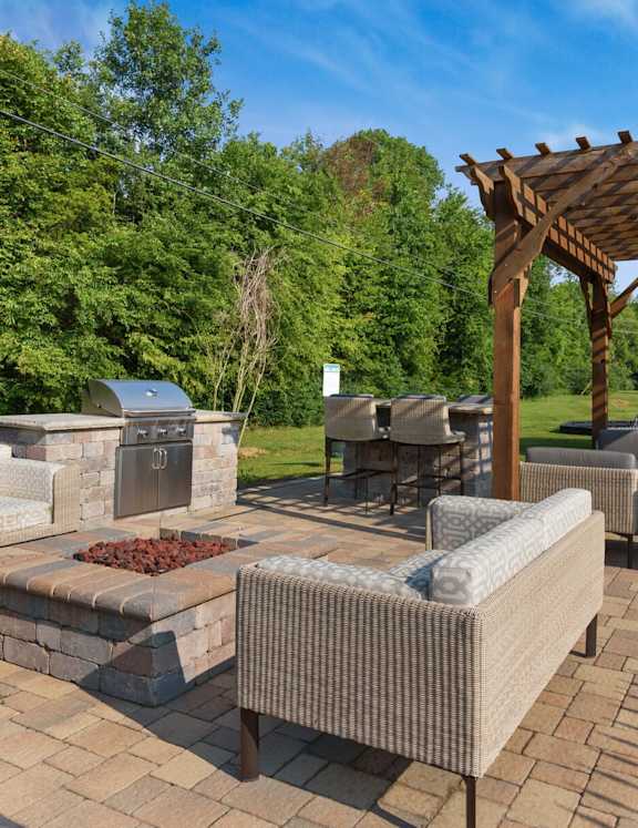 A patio with a fire pit and seating area.