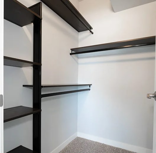 a walk in closet with empty shelves and a white wall at The Expo, Billings, Montana