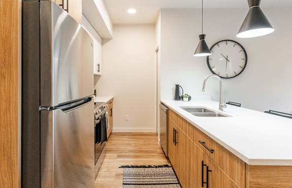 A modern kitchen with a stainless steel refrigerator and wooden cabinets.