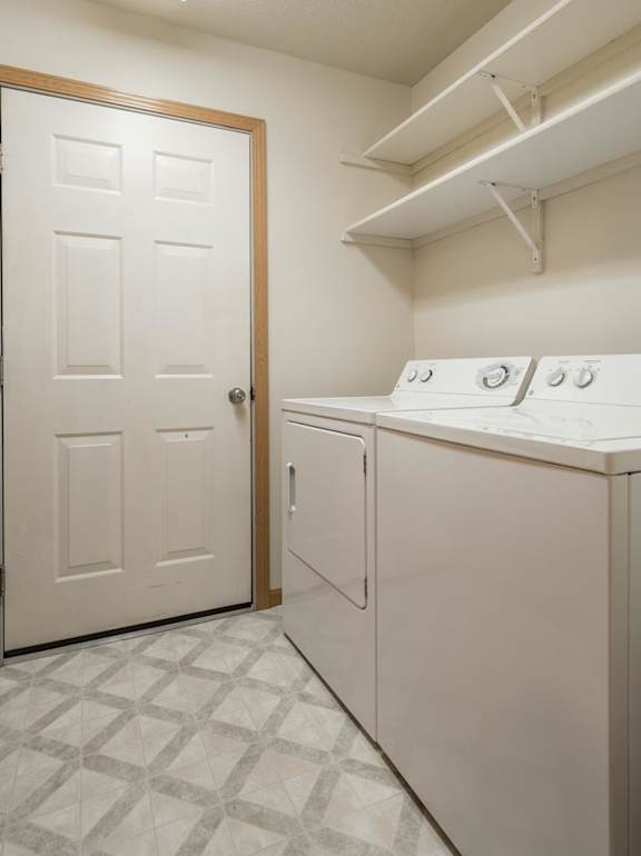 A white laundry room with a door and a washer and dryer.