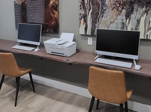 a desk with two laptops and a printer on it at Austin Crest Apartments, Reno, NV