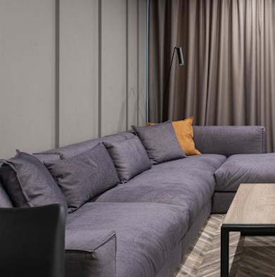 a living room with a purple couch and a tv