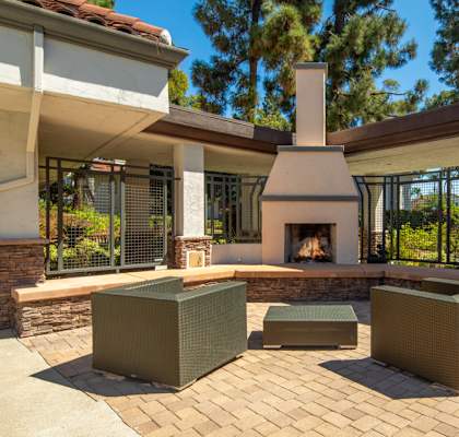 A patio with a fireplace and seating area.