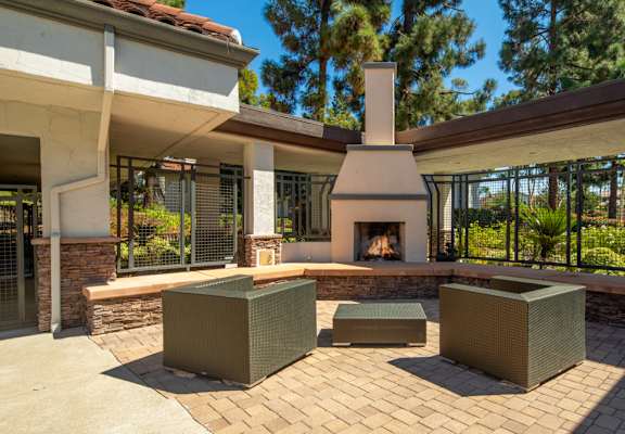 A patio with a fireplace and seating area.