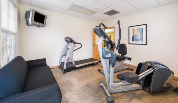 the gym has cardio equipment and a tv at Horace Mann apartments and townhomes in Gary, IN