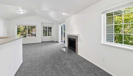 a living room with white walls and a fireplace