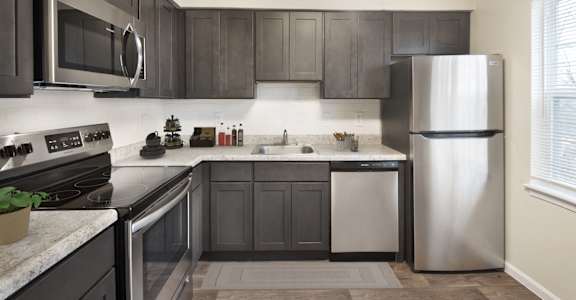 Kitchen with wooden cabinets at The Apartments at Owings Run, Owings Mills, MD, 21117