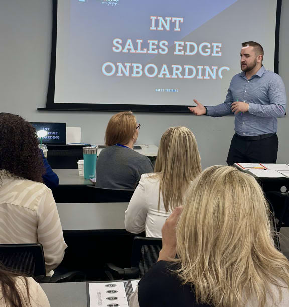 a man standing in front of a group of people in a classroom