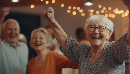 an older woman dancing with her hands in the air while others dance in the background