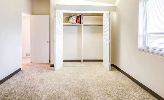 A room with a white door and a window with blinds.