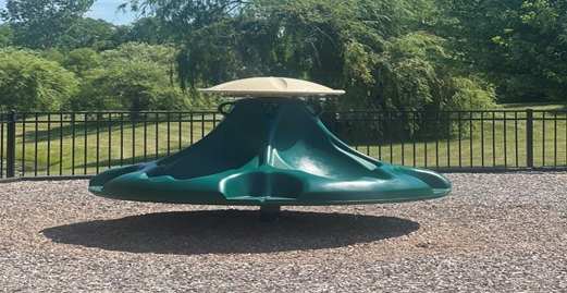 A green slide with a white top in a playground.