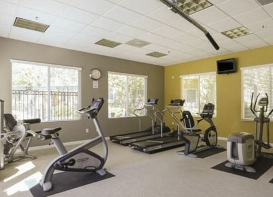 a room with a lot of exercise equipment in it  at Tesoro Senior Apartments, Porter Ranch