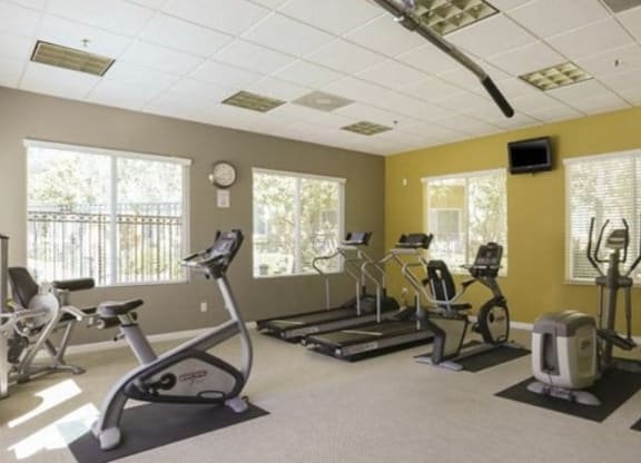 a room with a lot of exercise equipment in it  at Tesoro Senior Apartments, Porter Ranch