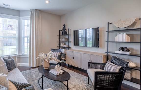 A living room with a black chair and a black coffee table.