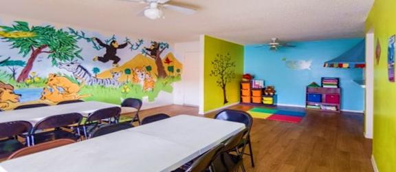 a room with a table and chairs and a mural on the wall