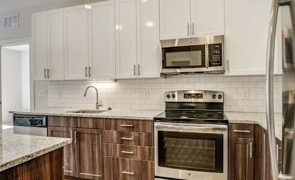 A kitchen with a stove, oven, microwave, and refrigerator.