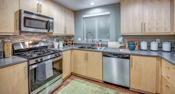 A kitchen with wooden cabinets and stainless steel appliances. at Esprit Apartments, Marina del Rey