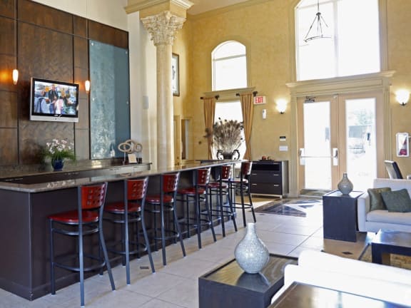 the lobby of a restaurant with a bar and stools