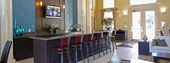 the lobby of a restaurant with a bar and stools