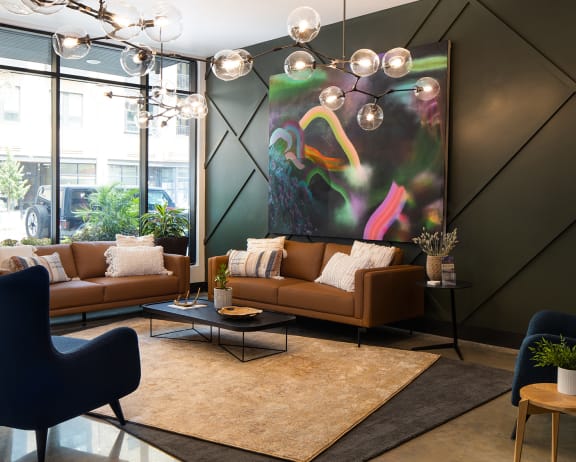 a living room with brown couches and a large painting at Kesler Apartments in Downtown Fargo, Fargo, North Dakota 58102